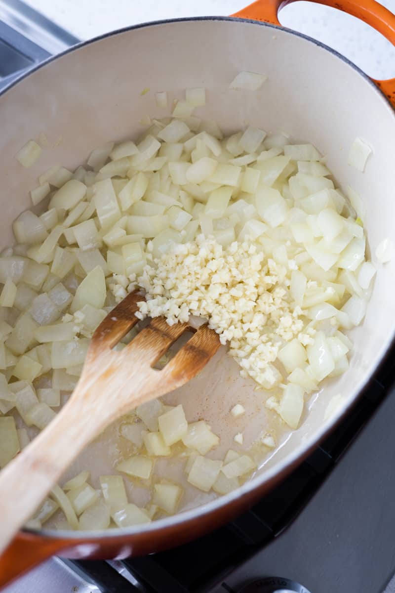 Onion and garlic cooking in a Dutch oven. 