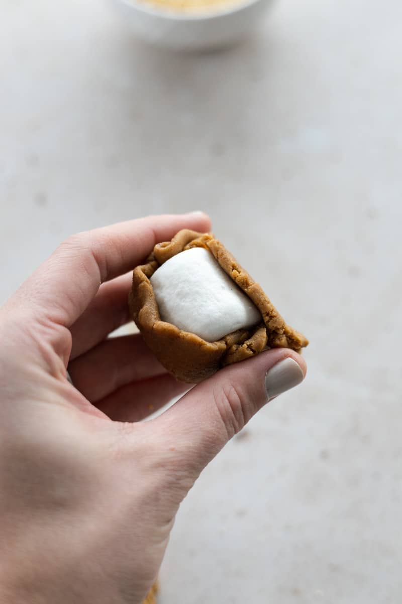 Dough being wrapped around the marshmallow. 