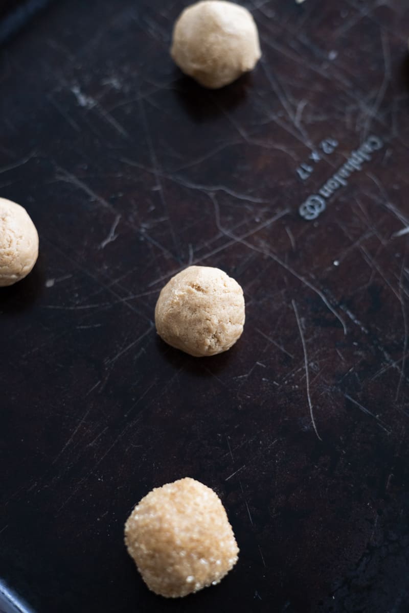 Dough balls rolled on a baking sheet. 