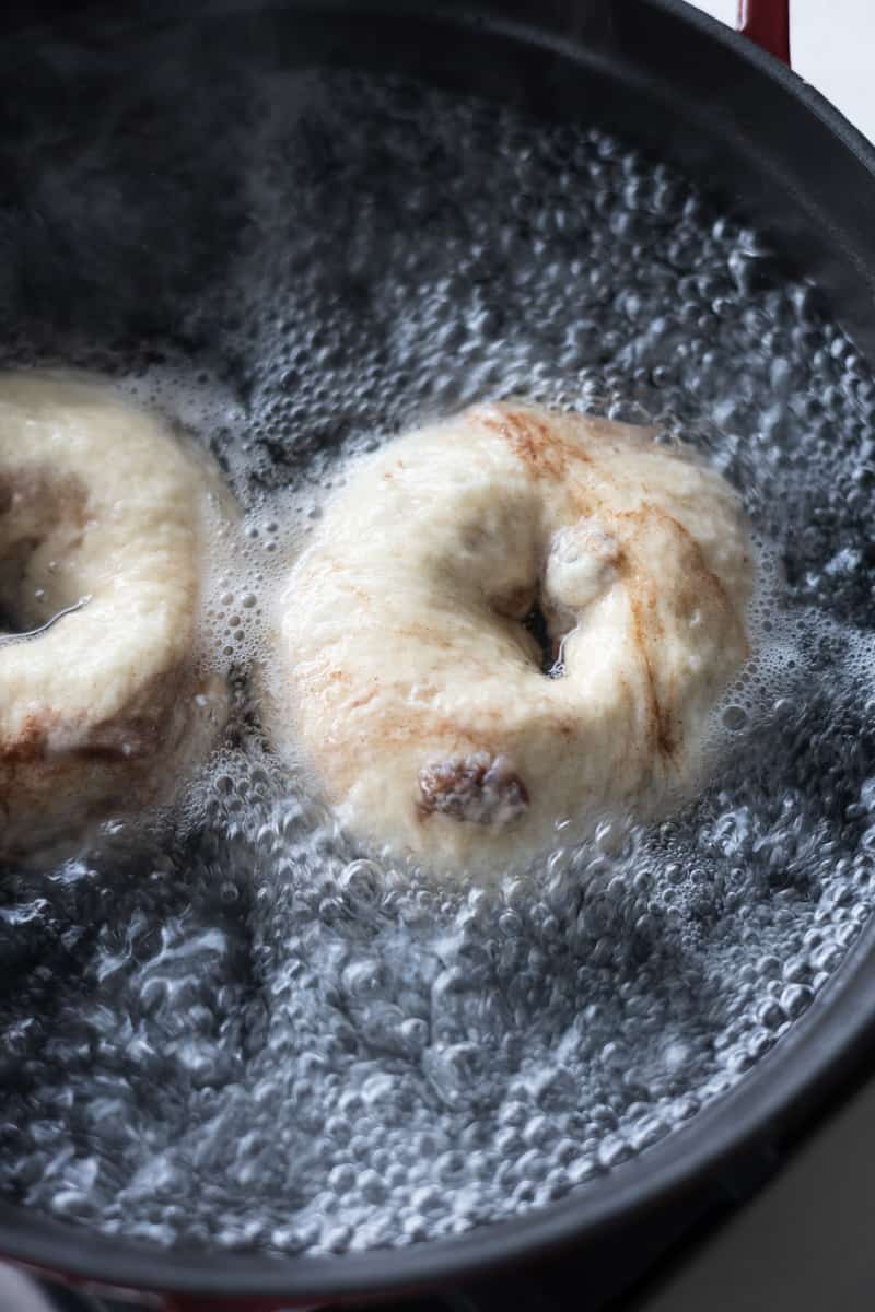 Bagel boiling in a pot of water. 
