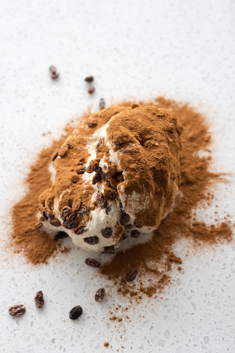 Dough sprinkled with raisins and cinnamon.