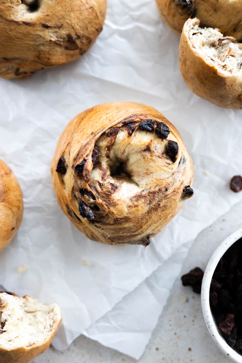 Cinnamon Raisin Sourdough Discard bagel on white parchment paper. 