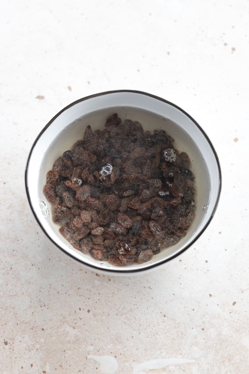 Raisins soaking in a bowl of water. 