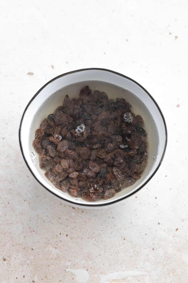Raisins soaking in a bowl of water.