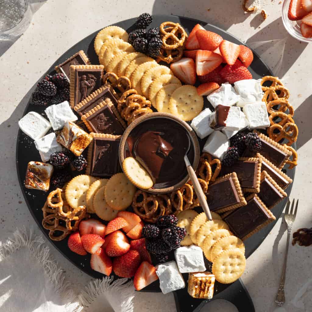 A Dessert Charcuterie Board with a bowl of chocolate dipping sauce in the center.