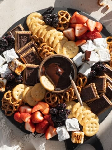 A Dessert Charcuterie Board with a bowl of chocolate dipping sauce in the center.