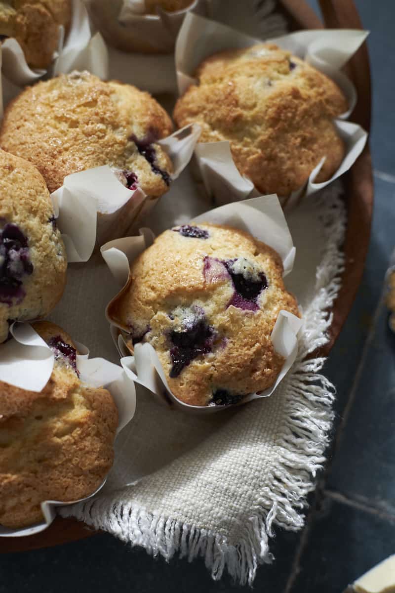 Sourdough Discard Blueberry Muffins on a wooden board. 