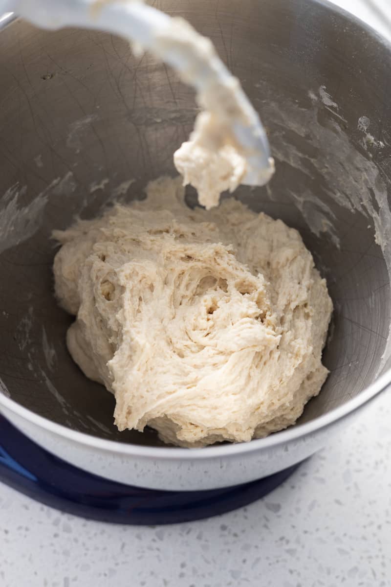 Shaggy dough in the bowl of a stand mixer.