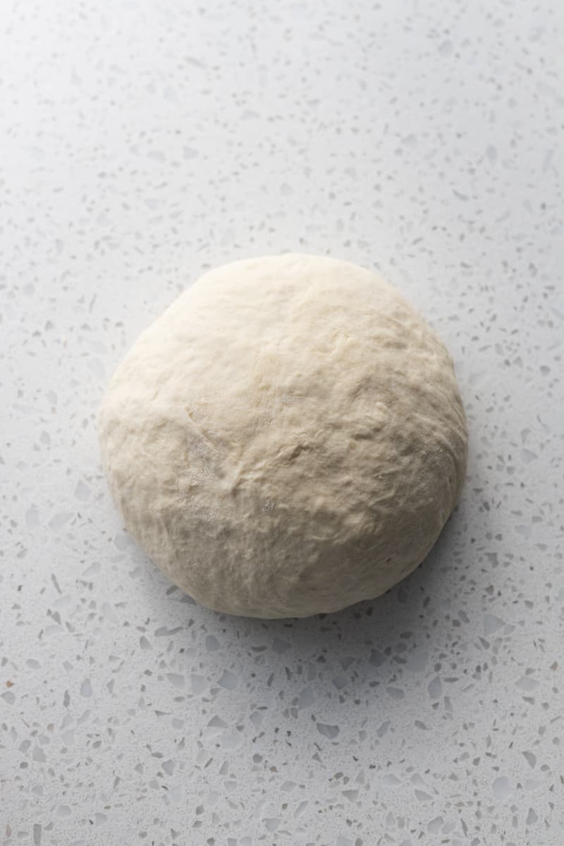 Dough in a ball on a work surface.