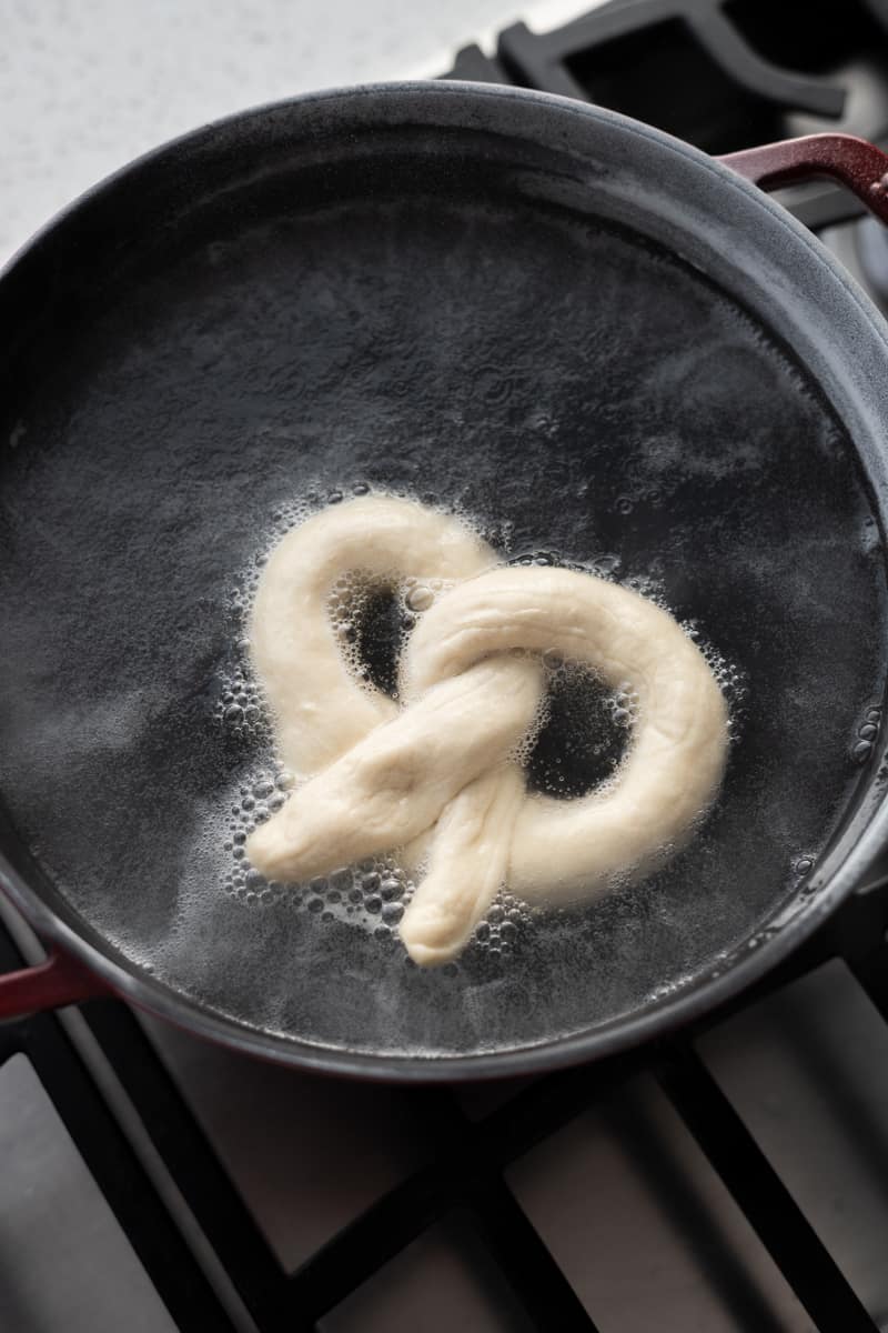 Pretzel boiling in a pot of water.