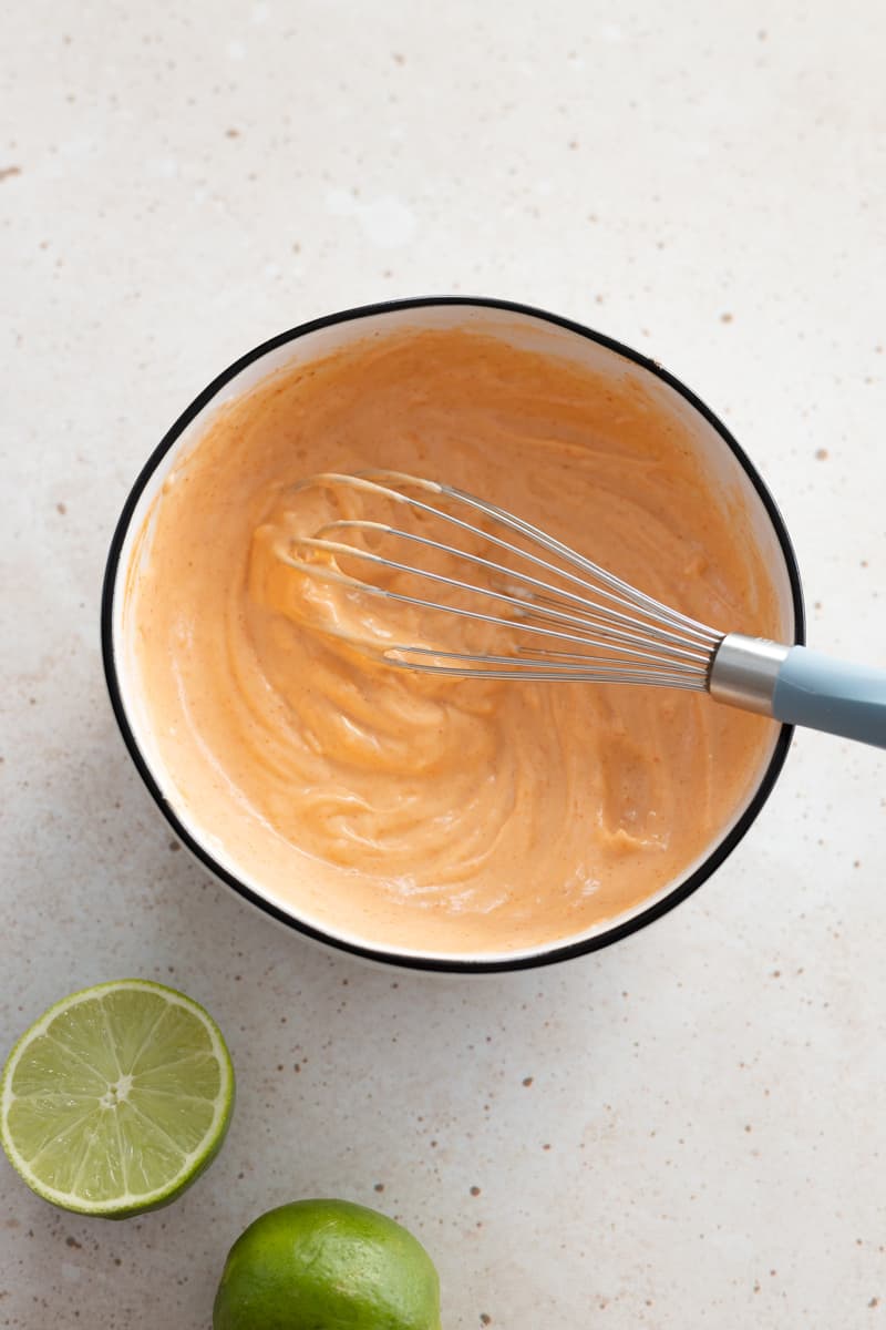 Sriracha Aioli mixed in a bowl with a whisk. 