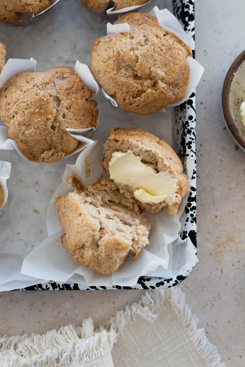 A halved Banana Sourdough Muffin with butter on one side.