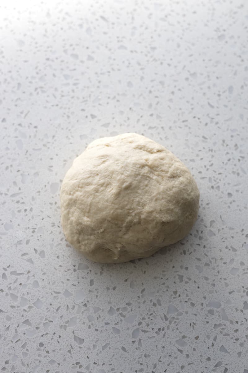 Dough on a white stone work surface.