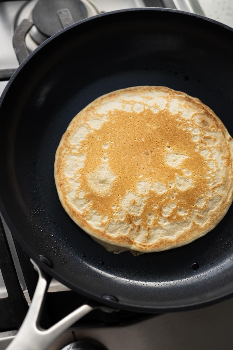 Lightly browned pancake in a skillet.