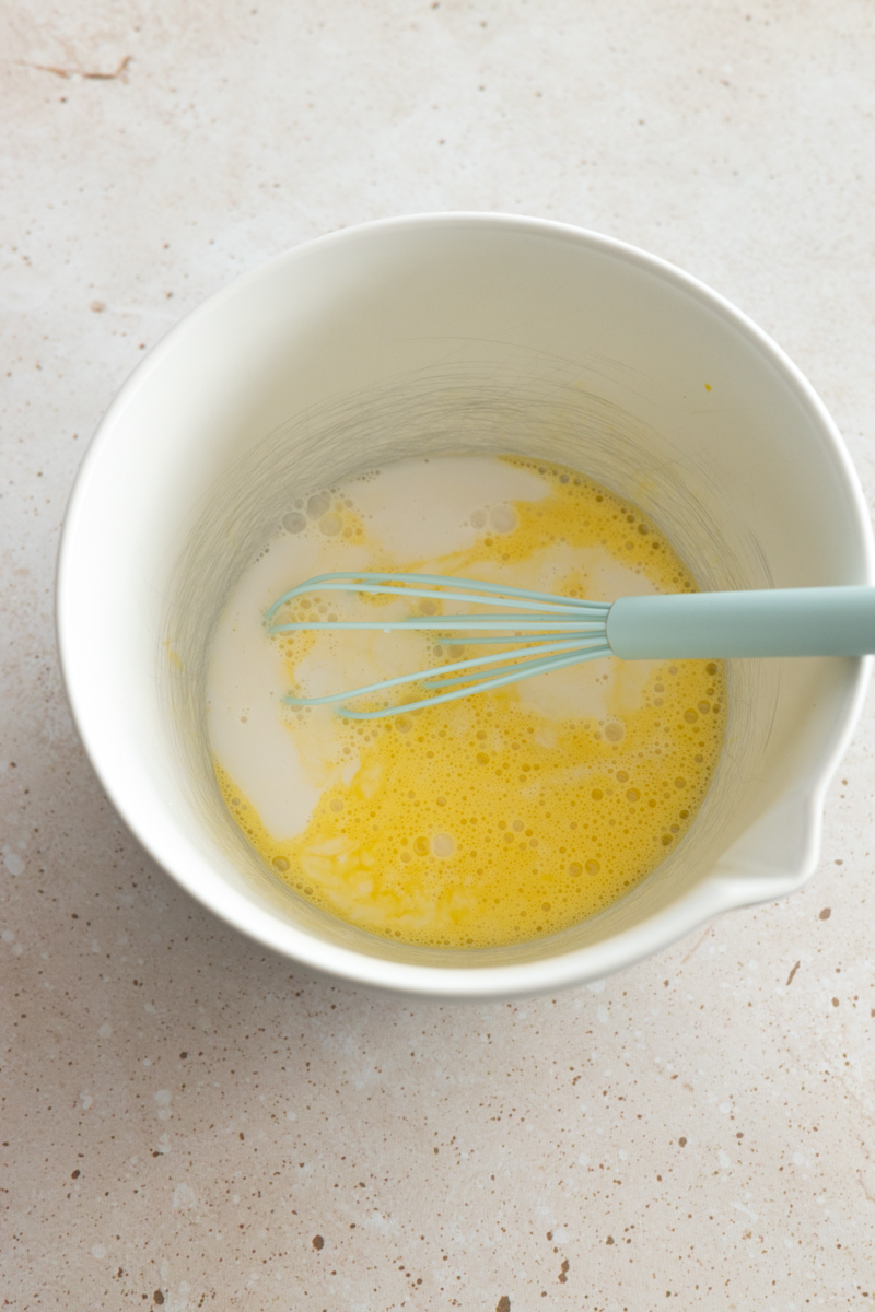 Milk and eggs in a mixing bowl.