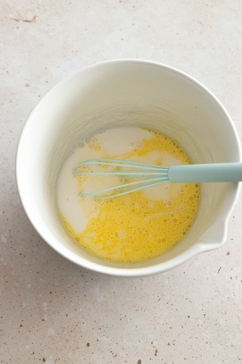 Milk and eggs in a mixing bowl.