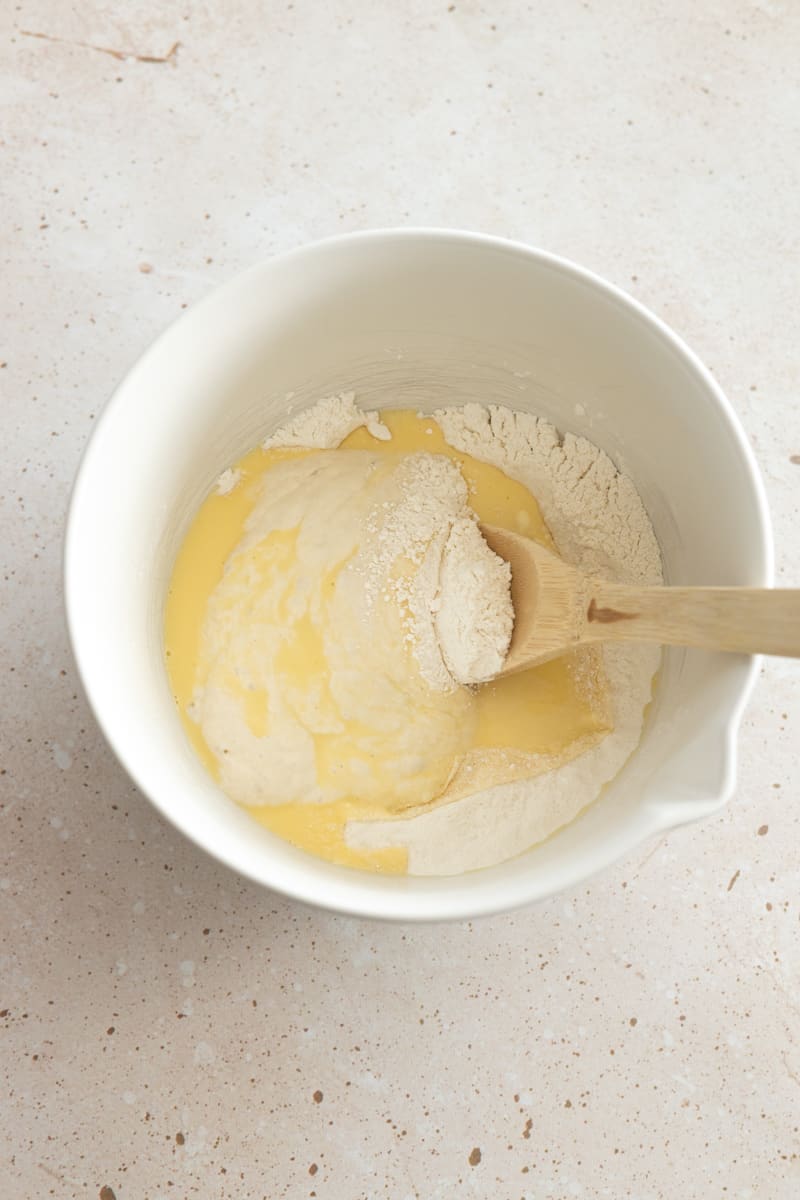 Wet and dry ingredients combined in a mixing bowl.