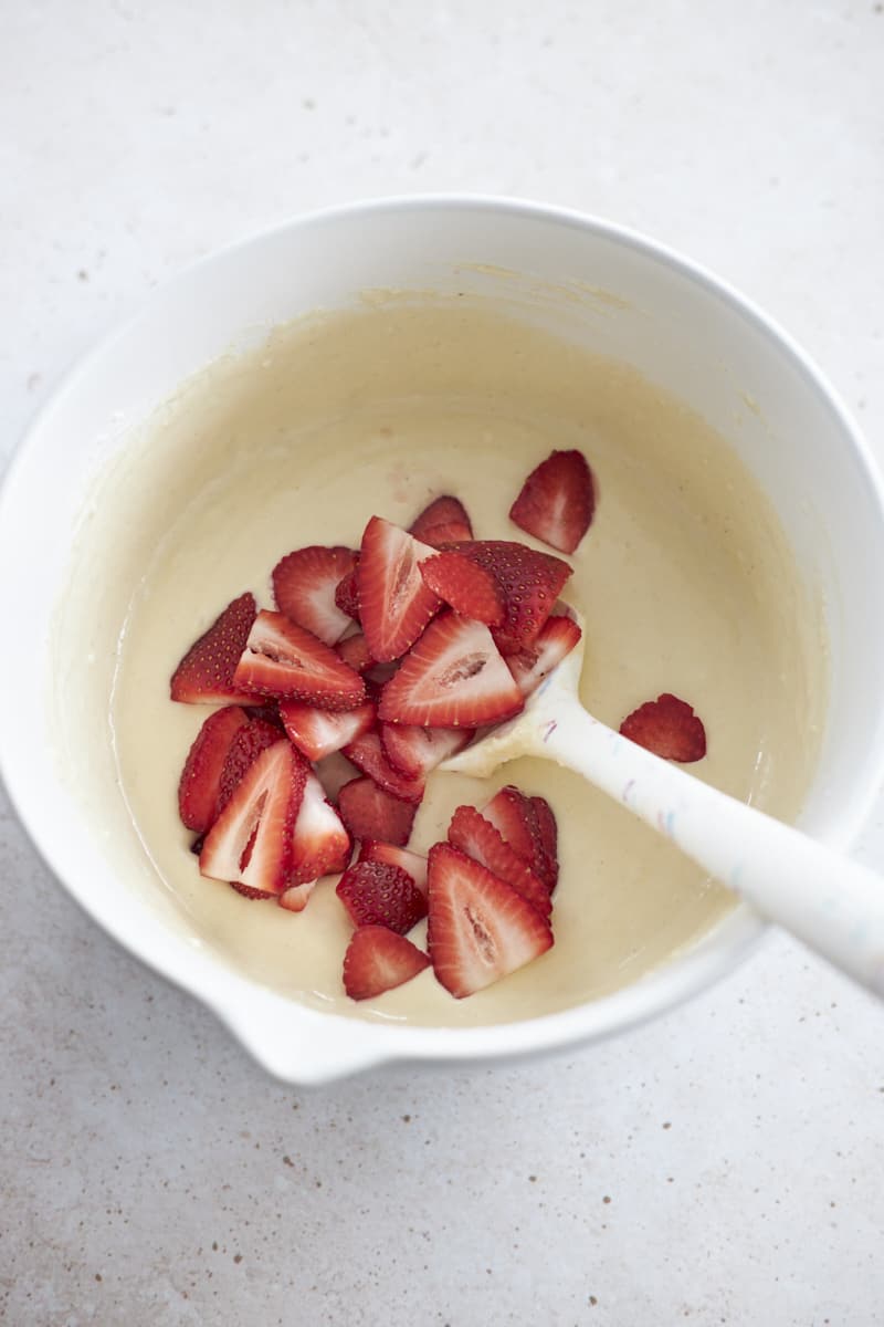 Strawberries added to the bowl of batter.
