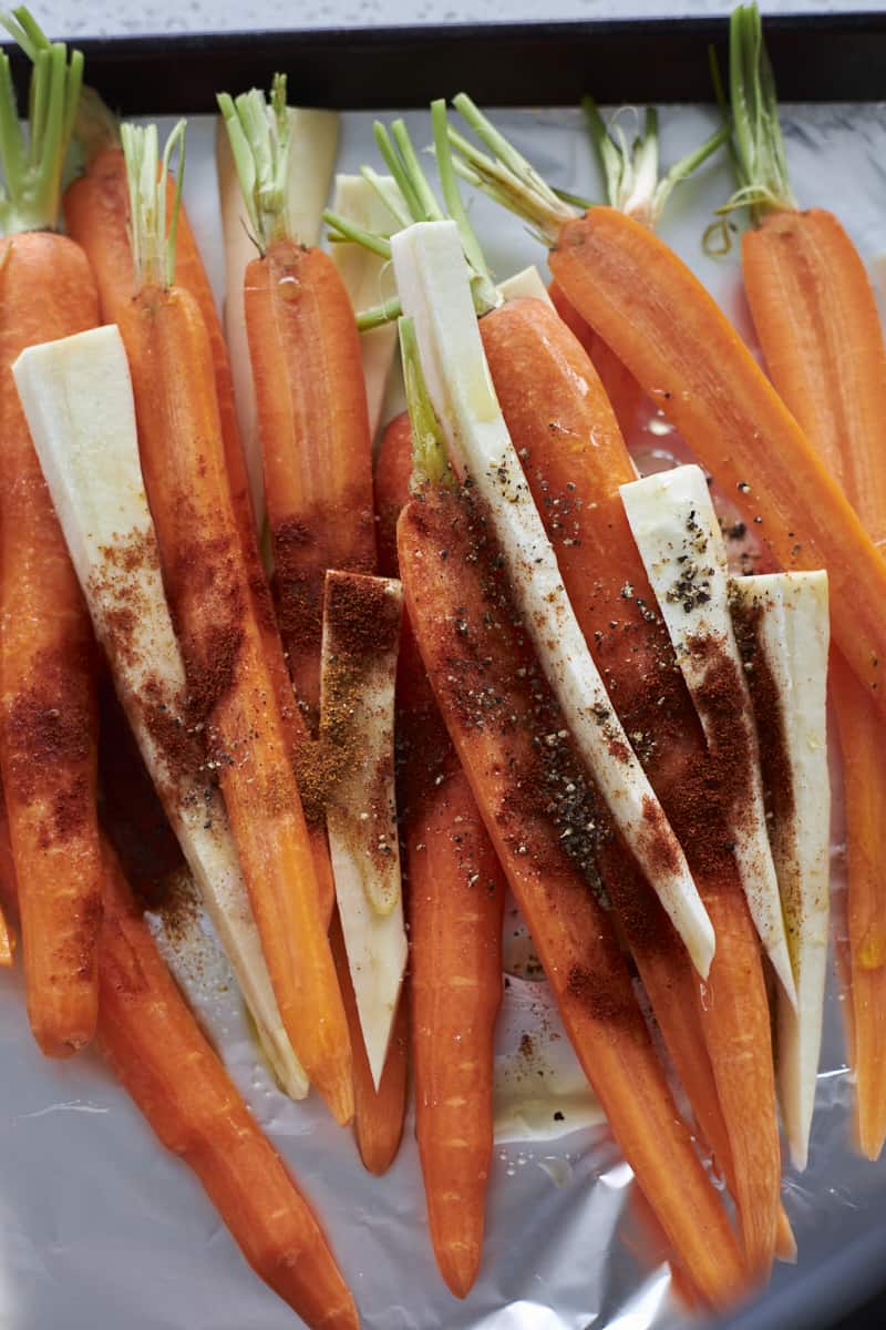Carrots and parsnips with olive oil, honey and spices drizzled on top.