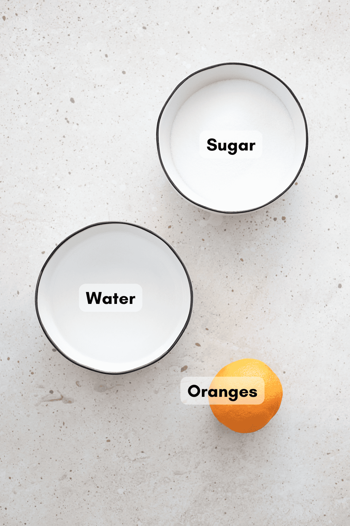 Ingredients for orange simple syrup in small white bowls.