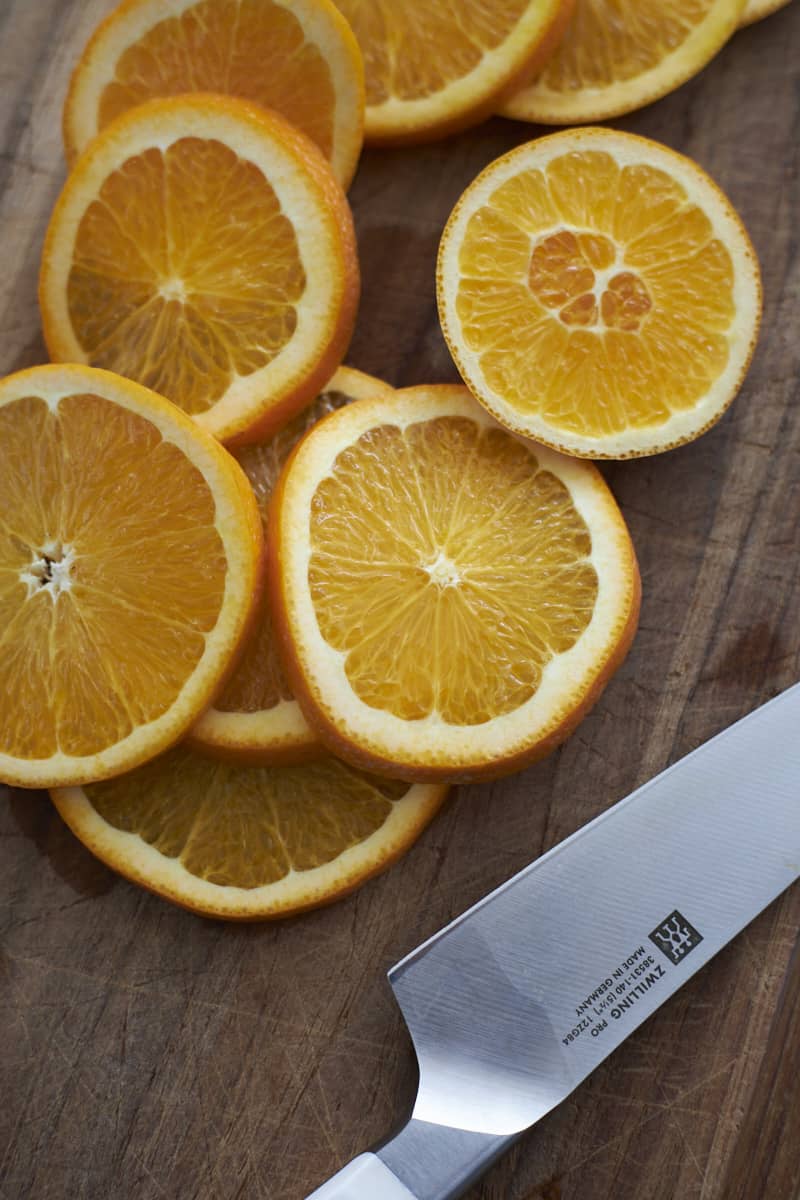 Sliced oranges on a wooden cutting board.