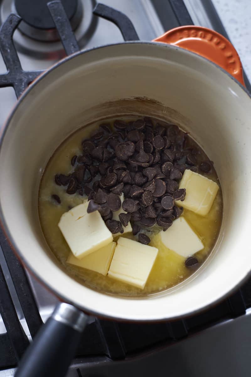 Chocolate and butter melting in a small saucepan.