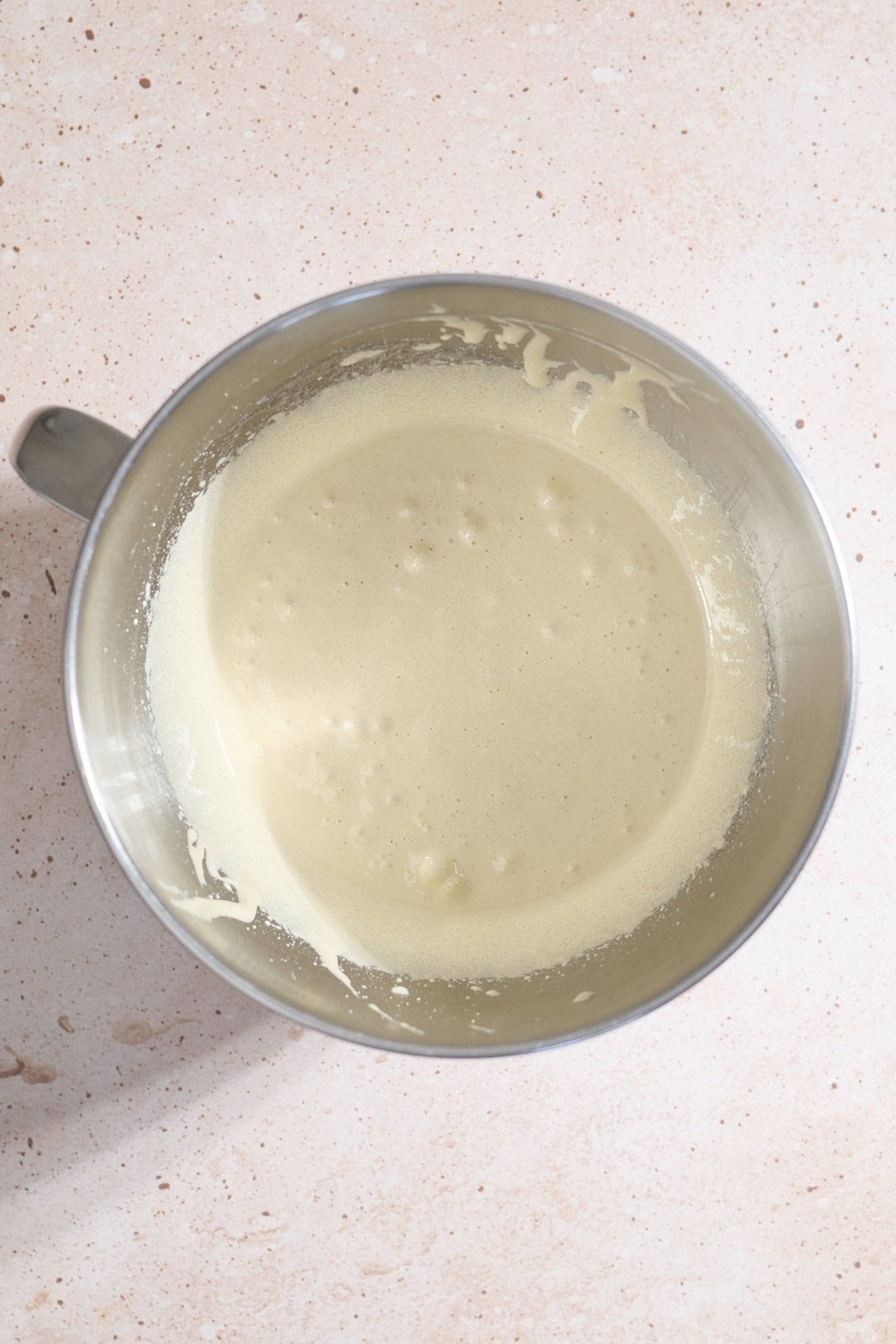 Eggs and sugar whipped in the bowl of a stand mixer.