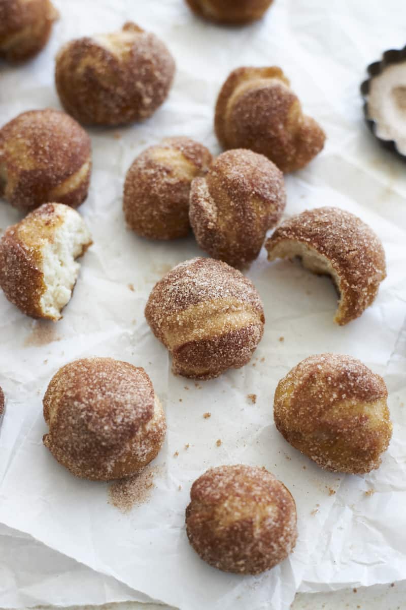 Sourdough Discard Pretzel Bites coated in cinnamon sugar on white parchment paper.