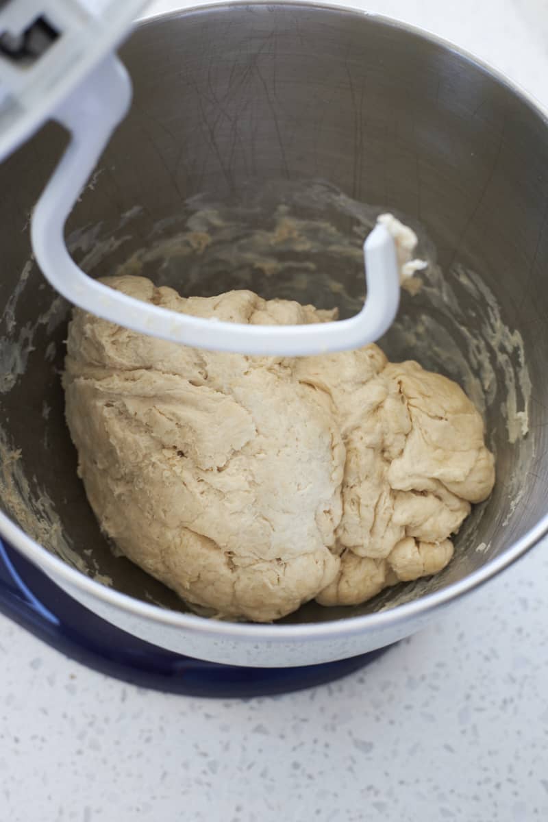 Shaggy dough in the bowl of a stand mixer.