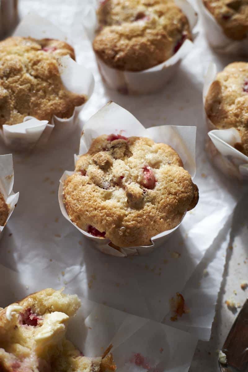 Strawberry Almond Muffins on white parchment paper.