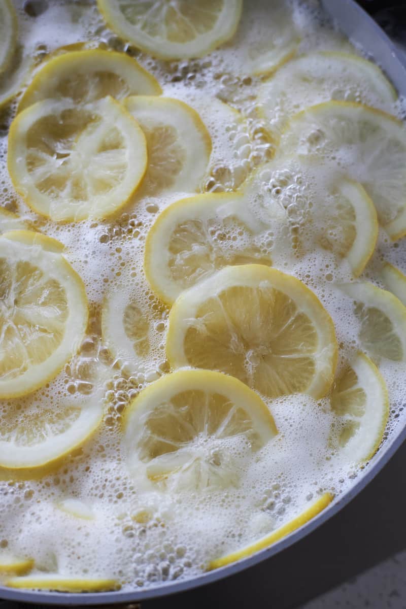 Lemon slices simmering in a large pot.