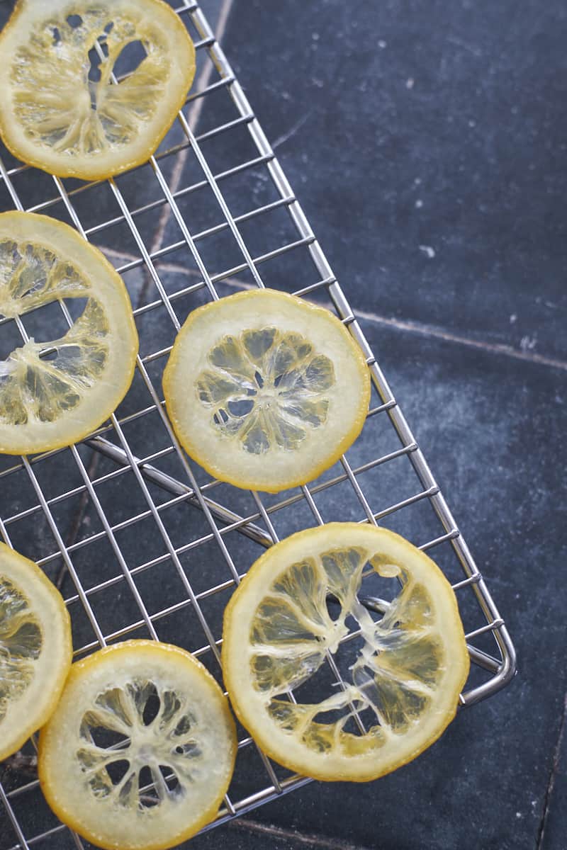 Candied Lemon Slices drying on a drying rack.