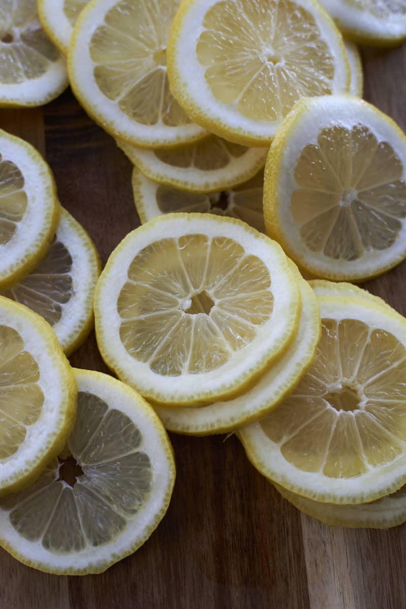 Sliced lemons on a wooden cutting board.