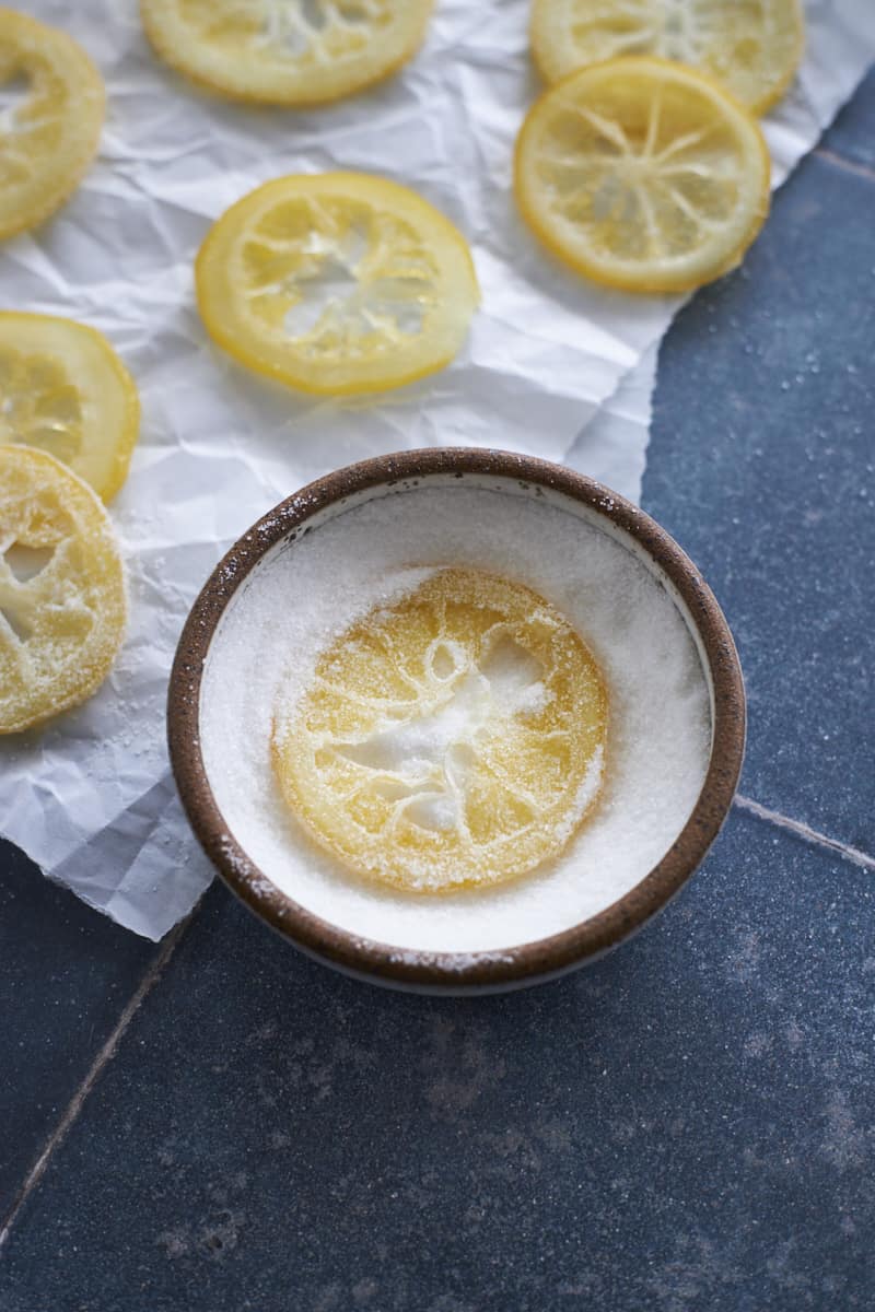 A lemon slice in a small bowl of granulated sugar.