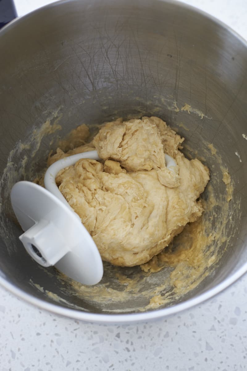 Shaggy dough in the bowl of a stand mixer.