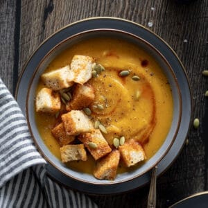 Butternut Squash and Carrot Soup in a bowl with jumbo croutons.