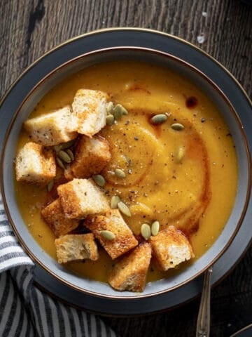 Butternut Squash and Carrot Soup in a bowl with jumbo croutons.