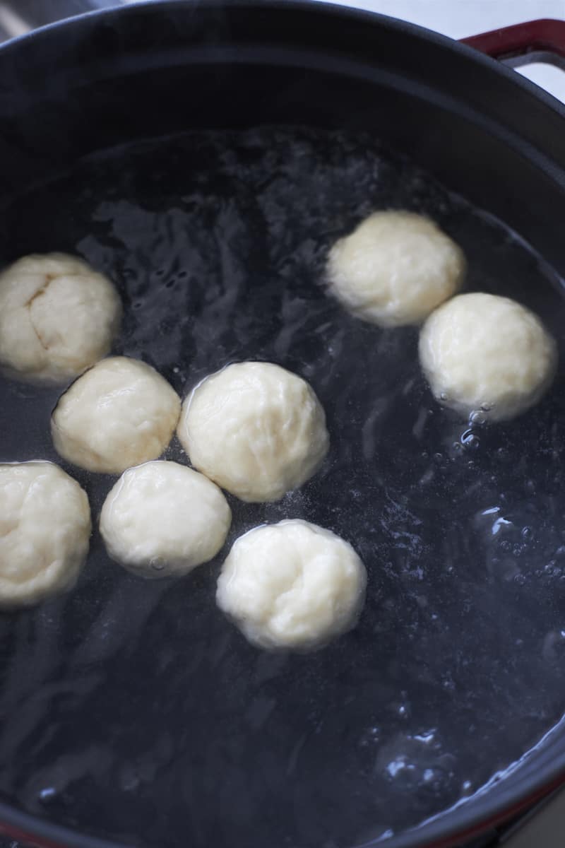 Bagel bites boiling in a large pot.