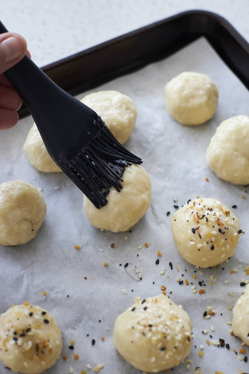 Brushing bagel bites with egg wash.