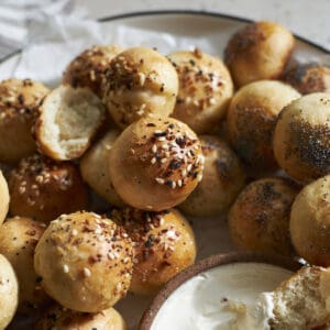 Sourdough discard bagel bites on a plate with cream cheese.