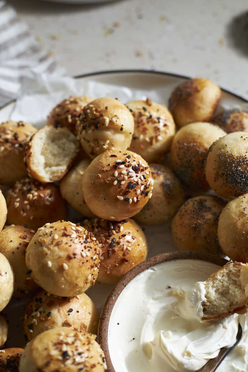 Sourdough discard bagel bites on a plate with cream cheese.