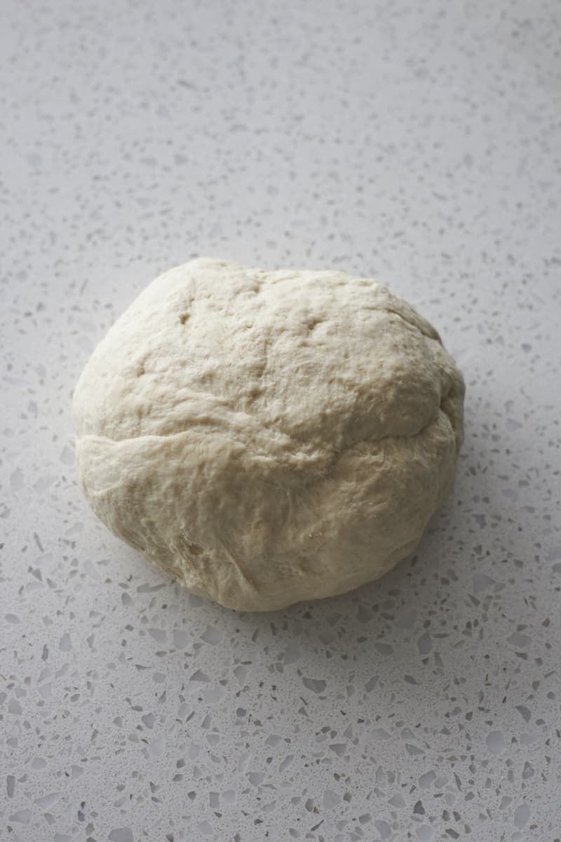 Smooth dough on a work surface after kneading.