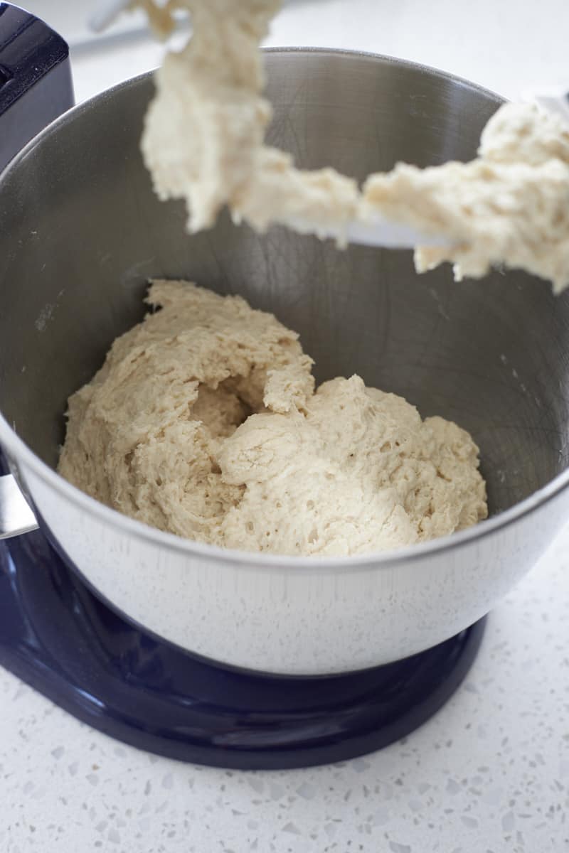 Shaggy dough in the bowl of a stand mixer.