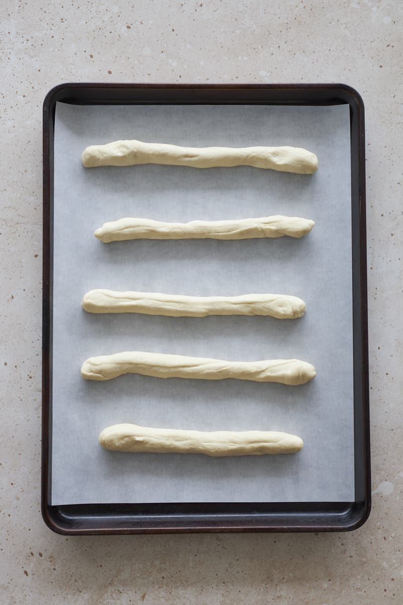 Breadsticks shaped on a baking sheet.