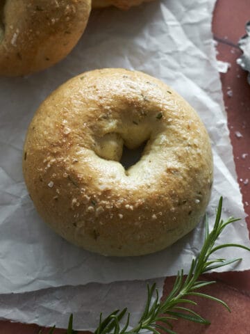 Rosemary Bagels on white parchment paper.