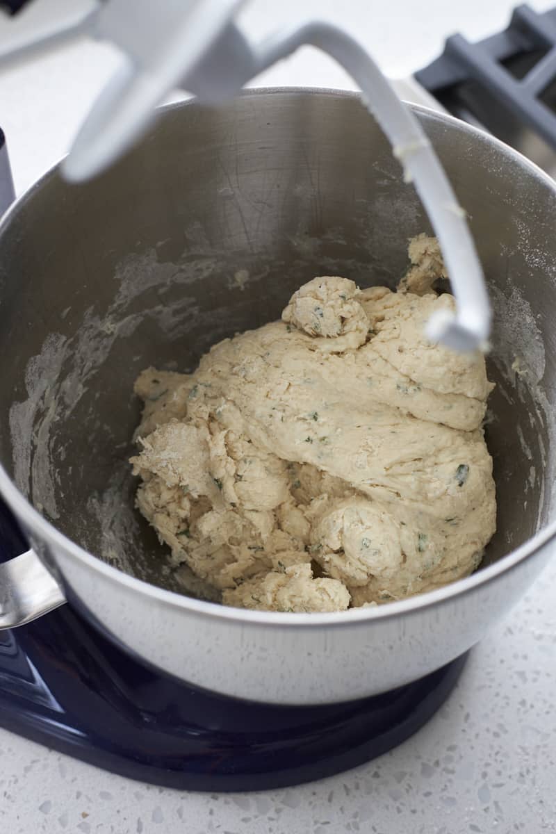 Shaggy dough in the bowl of a stand mixer.