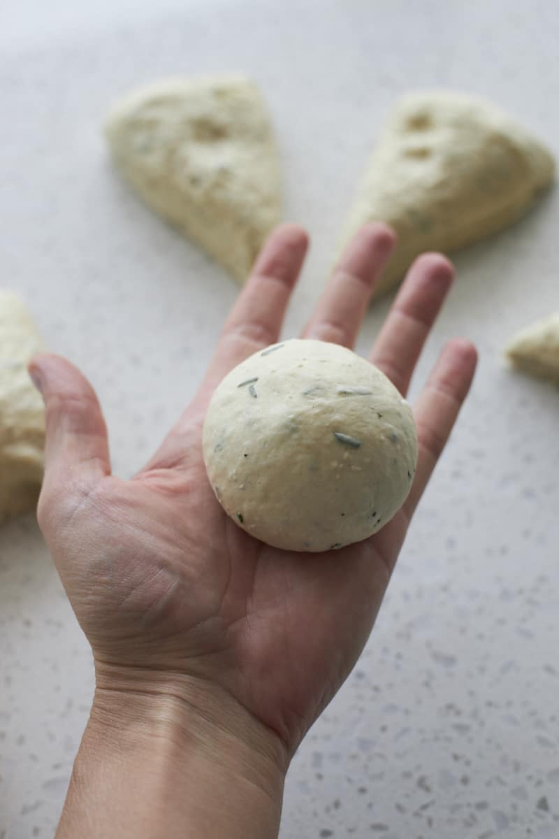 Dough in a ball in the palm of a hand.