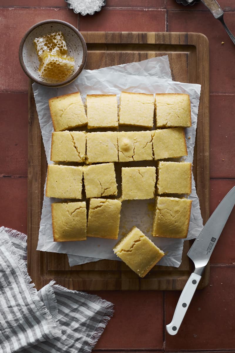 Sliced cornbread on a cutting board.