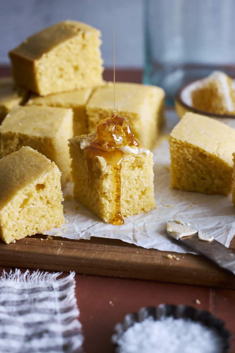 Sourdough Discard Cornbread being drizzled with honey.