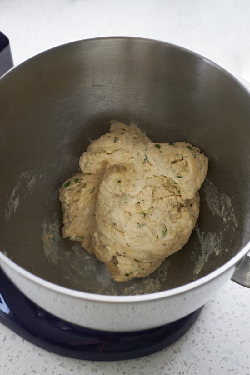 Shaggy dough in the bowl of a stand mixer.